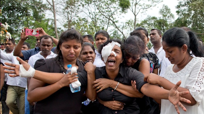 Anusha Kumari, with bandages on her left eye weeps during a mass burial for her husband, two children and three siblings, all victims of Easter Sunday bomb blast in Negombo, Sri Lanka.